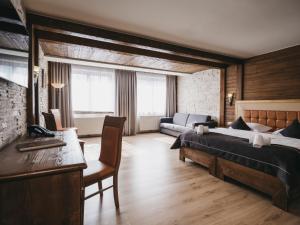 sypialnia z łóżkiem, biurkiem i kanapą w obiekcie Hotel Victoria by VAYA w Kaprunie