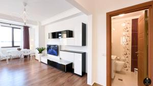 a living room with a tv on a wall at Deluxe Criss Solid Residence Mamaia in Mamaia