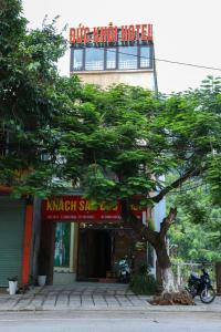 a tree in front of a building with a sign at Đức Khôi Hotel in Cao Bằng