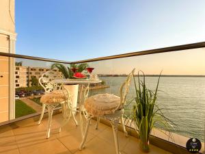 a balcony with a table and chairs and a view of the water at Deluxe Criss Solid Residence Mamaia in Mamaia