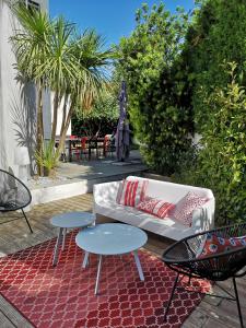 patio z 2 stołami, kanapą i krzesłami w obiekcie VILLA MONTPELLIER w Montpellier