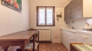 een keuken met een houten tafel en een eetkamer bij 3T - Affitti Brevi Italia in Modena