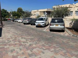 a row of parked cars in a parking lot at Buchman Cozy 1Bedroom Haven in Modi'in-Maccabim-Re'ut