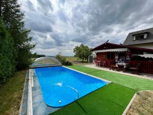 a large blue swimming pool next to a house at Chalupa na Končinách in Rychnov nad Kněžnou
