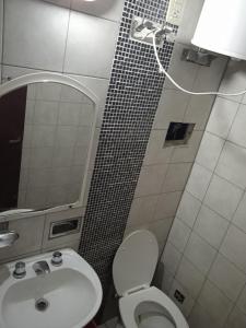 y baño con lavabo, aseo y espejo. en Dora alojamientos en Corrientes