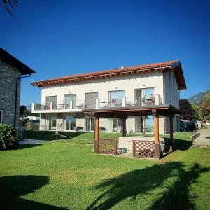 un gran edificio blanco con un gran patio en Resort le Vele Suites and Apartments en Domaso