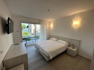 Resort le Vele Suites and Apartments في دوماسو: غرفة نوم مع سرير وبلكونة مع طاولة