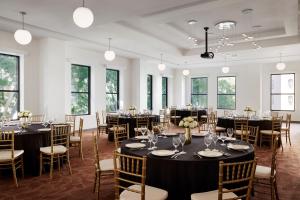 une chambre avec des tables et des chaises dans une chambre avec des fenêtres dans l'établissement Pasadena Hotel & Pool, à Pasadena