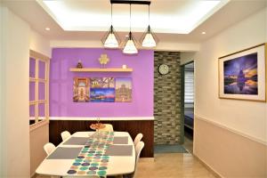 a dining room with purple walls and a table and chairs at Awedee Homestay Putrajaya in Putrajaya