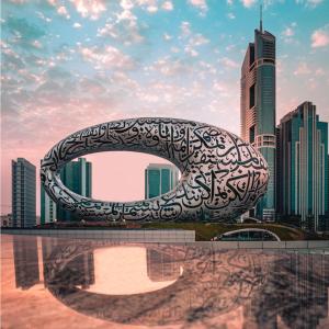 eine große Metallskulptur vor einer Stadt in der Unterkunft Millennium Plaza Downtown Suites in Dubai