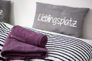 a bed with a pillow and purple towels on it at Ostsee Hausboot Schleswig Ostseeblick 1 in Schleswig