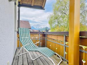 a rocking chair sitting on a balcony with a view at Haus Eggensberger in Fischen