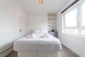 a white bedroom with a white bed and a window at Trendy Spacious 2BR apt near London Bridge in London