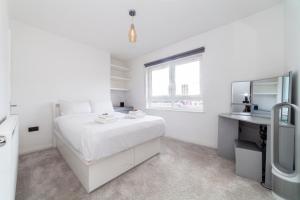 a white bedroom with a white bed and a desk at Trendy Spacious 2BR apt near London Bridge in London
