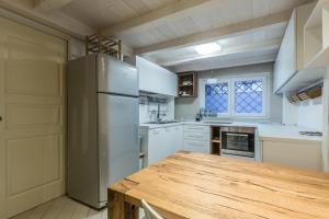 Una cocina con una mesa de madera y un refrigerador. en All'Ombra Della Luna, Bologna By Short Holidays, en Bolonia