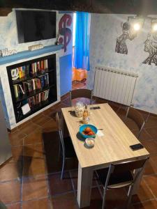 stół i krzesła w pokoju z półką na książki w obiekcie Ai Muri Dipinti w mieście Perugia