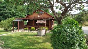 una pequeña cabaña en un patio con un árbol en Drewniany domek, en Wielopole Skrzyńskie