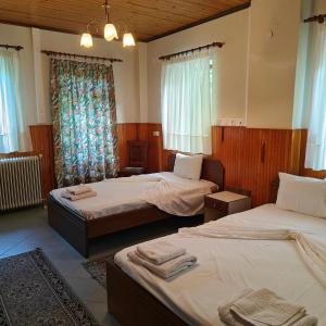 a hotel room with two beds with towels on them at Anilio Rooms in Anilio Metsovo
