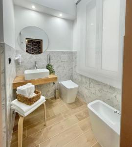 a white bathroom with a sink and a toilet at Regina Elena Rooms in Pescara