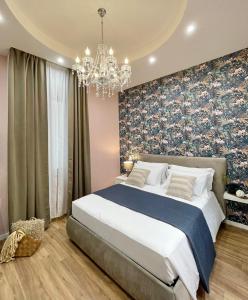 a bedroom with a large bed and a chandelier at Regina Elena Rooms in Pescara