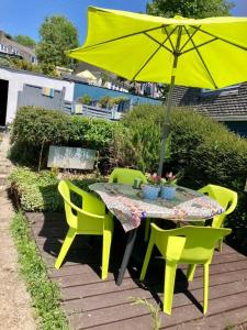 Guest house Truro garden retreat في Kenwyn: طاولة وكراسي مع مظلة صفراء
