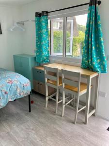 um quarto com uma mesa, cadeiras e uma cama em Guest house Truro garden retreat em Kenwyn