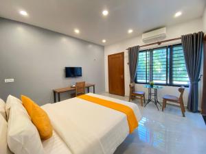 a bedroom with a large white bed and a table at Madam Sokha Homesteading in Siem Reap