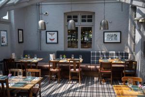 a restaurant with tables and chairs in a room at Cedars Inn by Greene King Inns in Barnstaple