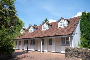ein weißes Haus mit braunem Dach in der Unterkunft Cedars Inn by Greene King Inns in Barnstaple