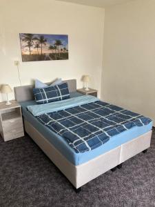 1 dormitorio con 1 cama con sábanas azules y palmeras en Ferienhaus Katharina, 