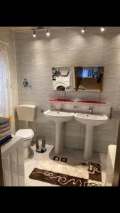 a bathroom with two sinks and a toilet at Ferienhaus Katharina 