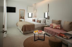 een hotelkamer met een bed en een bank bij Anapollo Boutique Hotel Adults Only in Naxos Chora