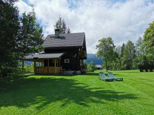 una casa con due sedie seduta sull'erba di Ferienhäuser Stohl a Mariapfarr