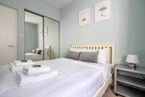 a bedroom with a large white bed with towels on it at Stunning Central 2BR Flat btw Soho & Covent Garden in London