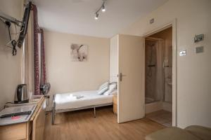 ロンドンにあるFlexistay Aparthotel Tootingのベッド1台とシャワー付きの小さな客室です。