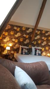 プロエルメルにあるManoir de Barbotinの花の壁のベッドルーム1室(ベッド2台付)