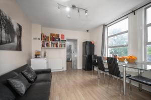 倫敦的住宿－Flexistay Aparthotel Tooting，客厅配有黑色沙发和桌子