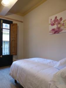 a bedroom with a white bed and a window at Apartamento Ábside de San Juan II in Estella