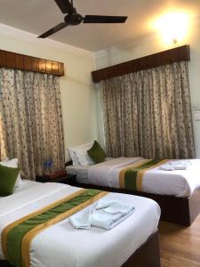 two beds in a hotel room with curtains at Bouddha Green Hotel in Kathmandu