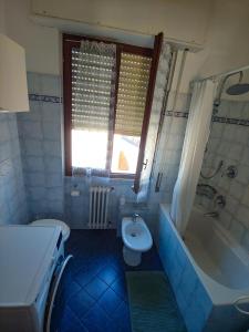 a bathroom with a tub and a toilet and a sink at Luminoso appartamento vacanze vista mare in centro in Celle Ligure