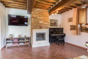 a living room with a fireplace and a piano at PODERE MONTIONI 6&2, Emma Villas in Rapolano Terme