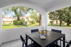 una sala da pranzo con tavolo e due bicchieri di vino di Helion Resort a Gouviá