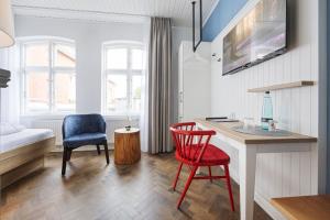 um quarto com uma secretária, 2 cadeiras e uma cama em Zum Goldenen Anker em Tönning