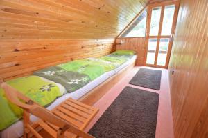 a wooden cabin with a bed and a chair in it at Apartma Šťastný III in Bechyně