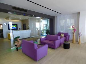 a living room with purple couches and a mirror at Mon Repos in Lido di Jesolo