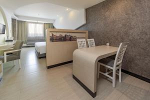 Habitación de hotel con cama, mesa y sillas en ASTON Cirebon Hotel and Convention Center, en Cirebon