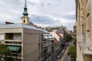 widok na ulicę miejską z wieżą kościelną w obiekcie d.Five Döbrentei Apartment w Budapeszcie