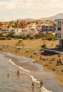 a beach with people in the water and buildings at Beachback Studio Apt Low-cost nearby Airport in La Garita