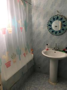 La salle de bains est pourvue d'un lavabo et d'un miroir. dans l'établissement Maison Avec Jardin Garage, à La Marsa
