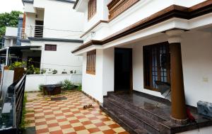a house with an open door and a checkered floor at 4BR AC House near Edappally Lulu Mall & AIMS Kochi in Ernakulam